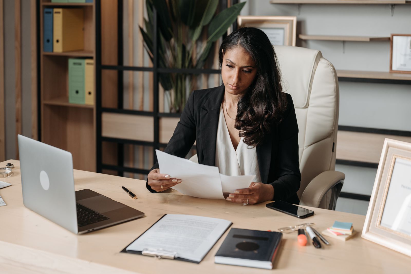 Woman at a workplace desk documenting security procedures on a laptop